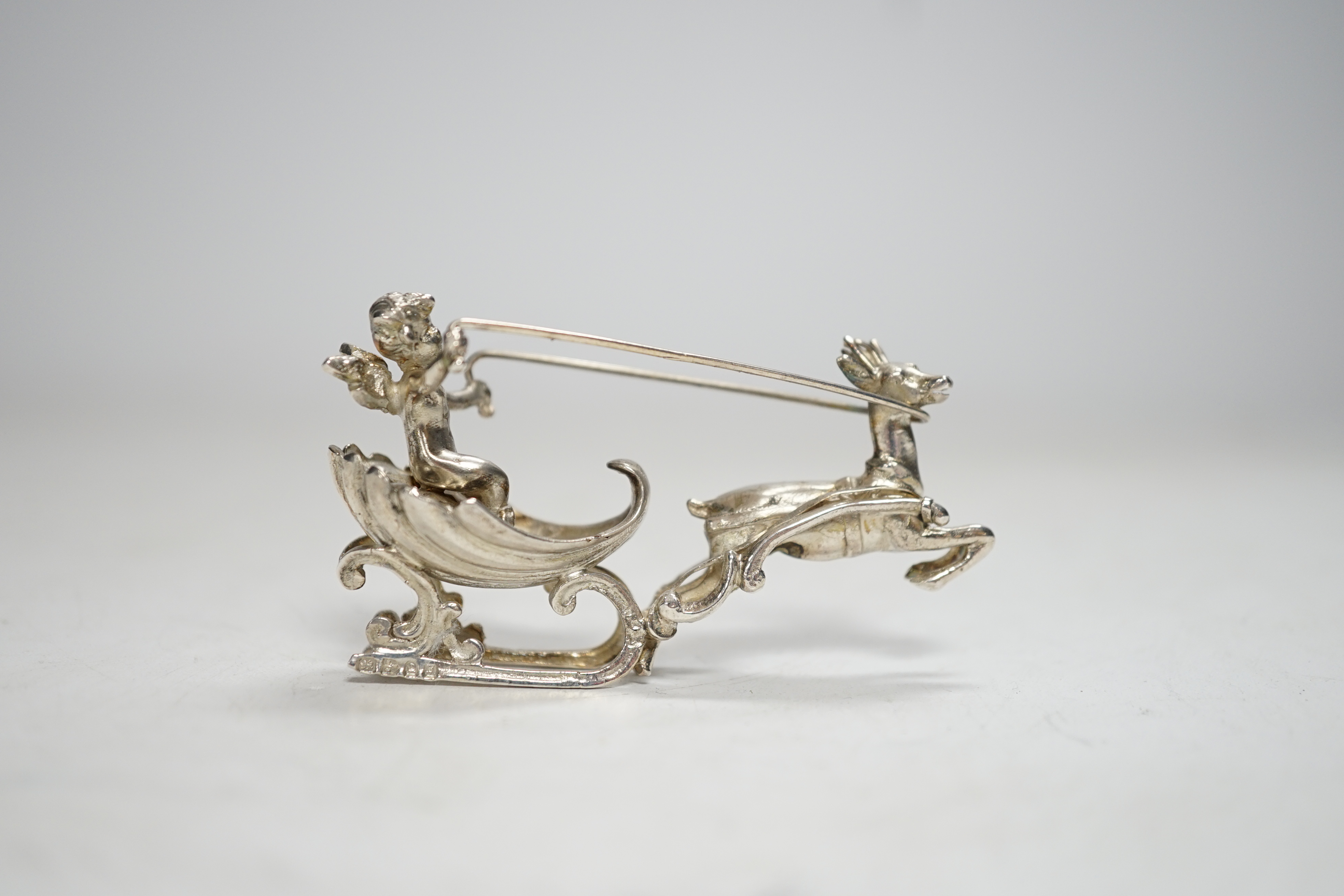 A late 19th century Hanau miniature silver model of a deer pulling a sleigh with cherub, by Berthold Muller, import marks for Chester, 1899, length 64mm.